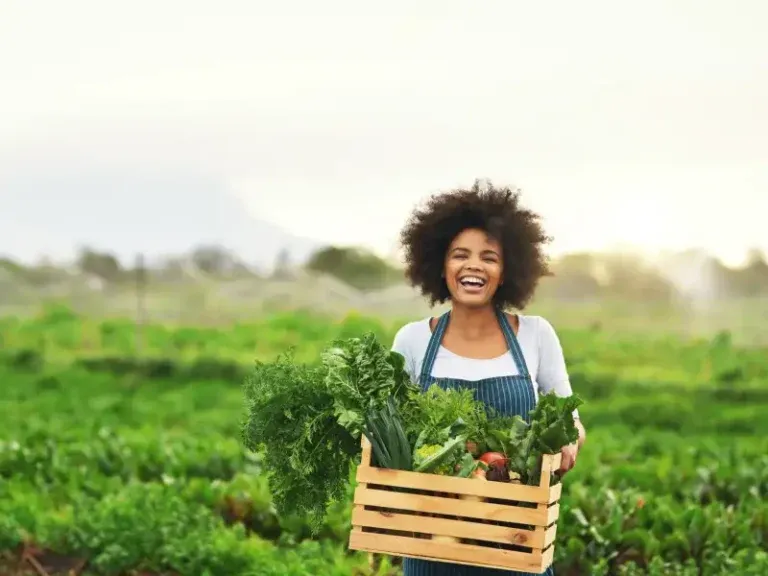 Productora con una caja de vegetales frescos